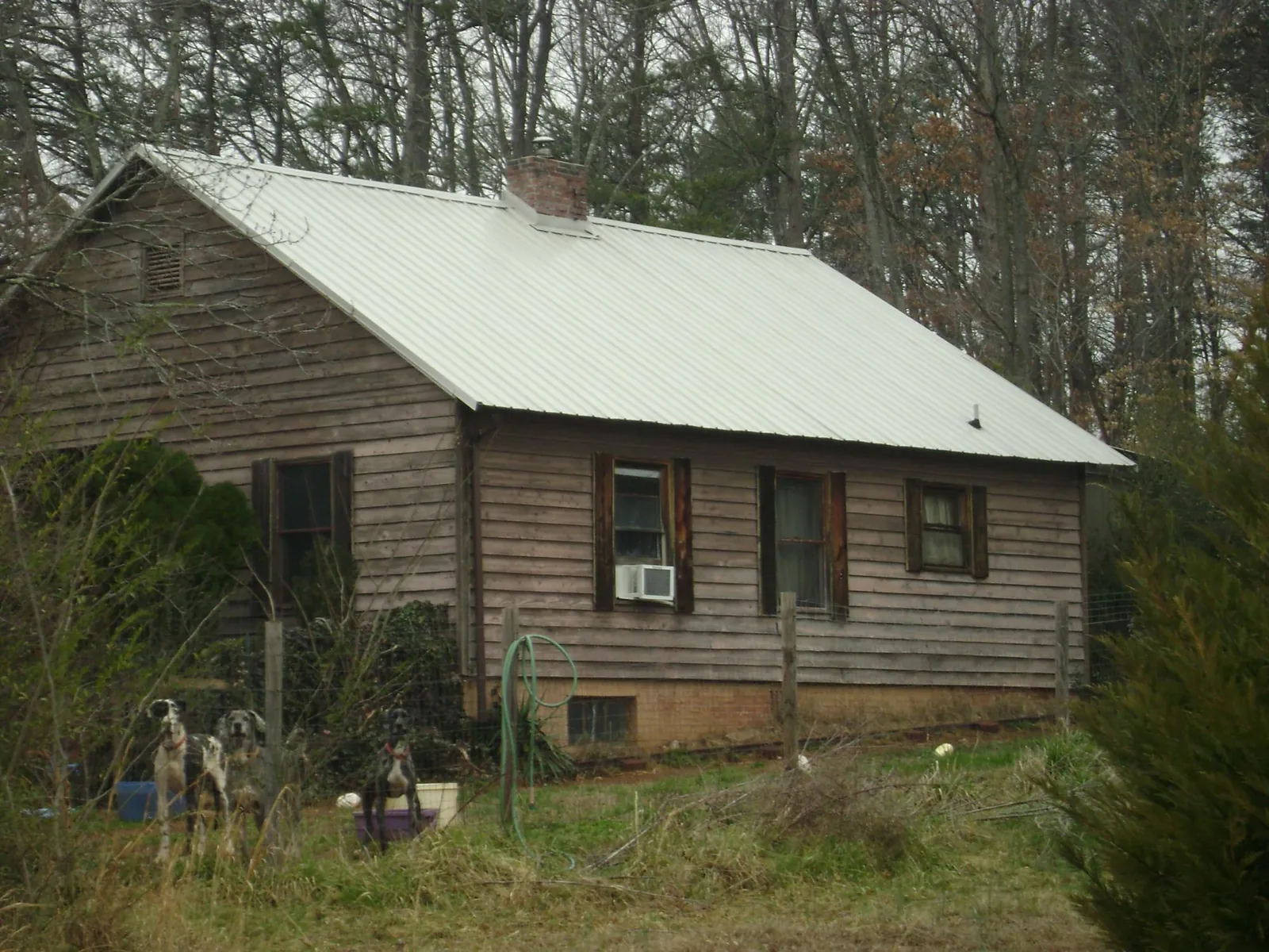 White metal roof on an old wood sided farmhouse, from a Asphalt Shingle Roof Repair job in Harrisville